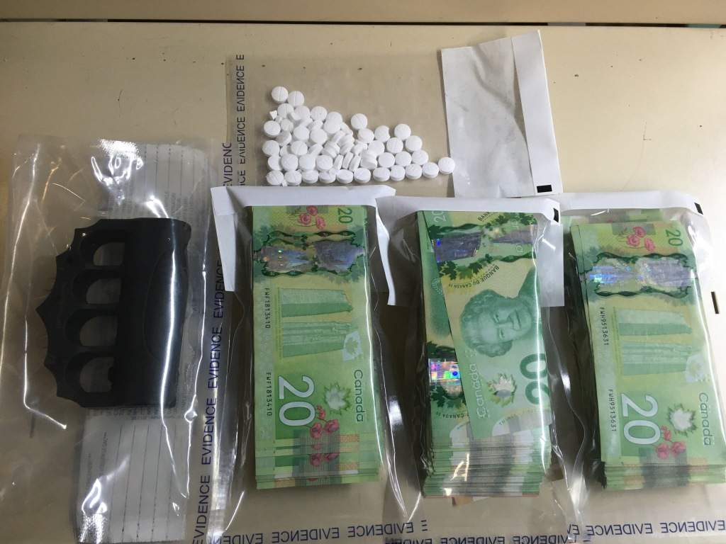 Police found drugs, cash, and electric brass knuckles during a raid at a Thompson home Monday.