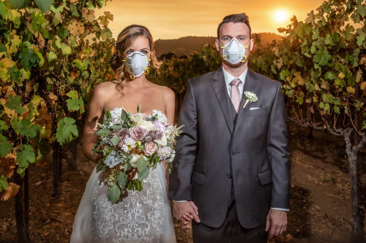 Katie and Curtis Ferland pose for a wedding photo at Chateau St. Jean in Sonoma County, Calif., amid a wildfire on Oct. 26, 2019.