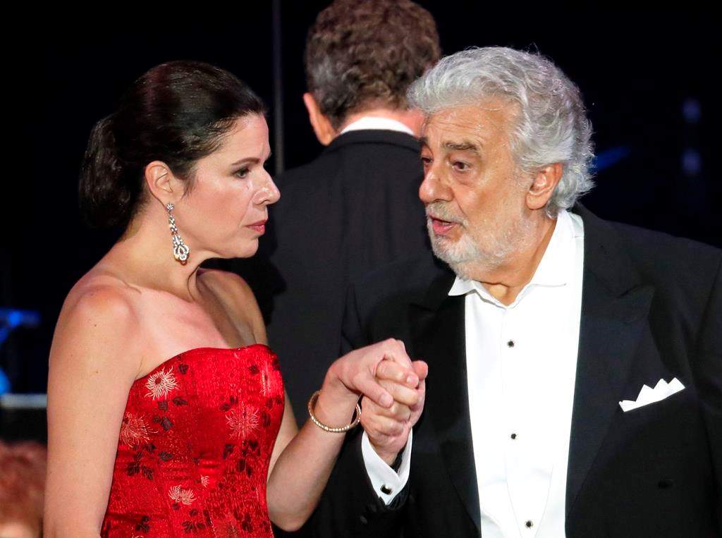 In this file photo taken on Aug. 28, 2019, Opera star Placido Domingo holds the hand of Ana Maria Martinez at the end of a concert in Szeged, Hungary.