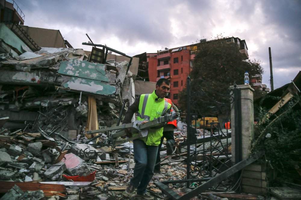 A worker removes debris from a damaged building in Durres, western Albania, Wednesday, Nov. 27, 2019.