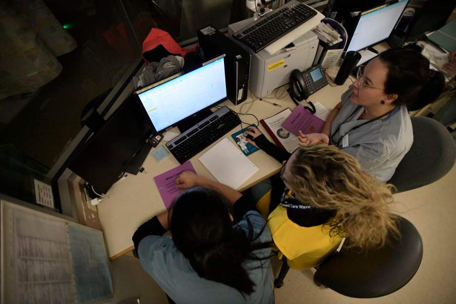 Registered nurses Stephanie Sarafinchen, Laura Vey and Tanya Gladue review assessments on the new Connect Care interface in the burn unit at the University of Alberta Hospital on Oct. 4, 2019.