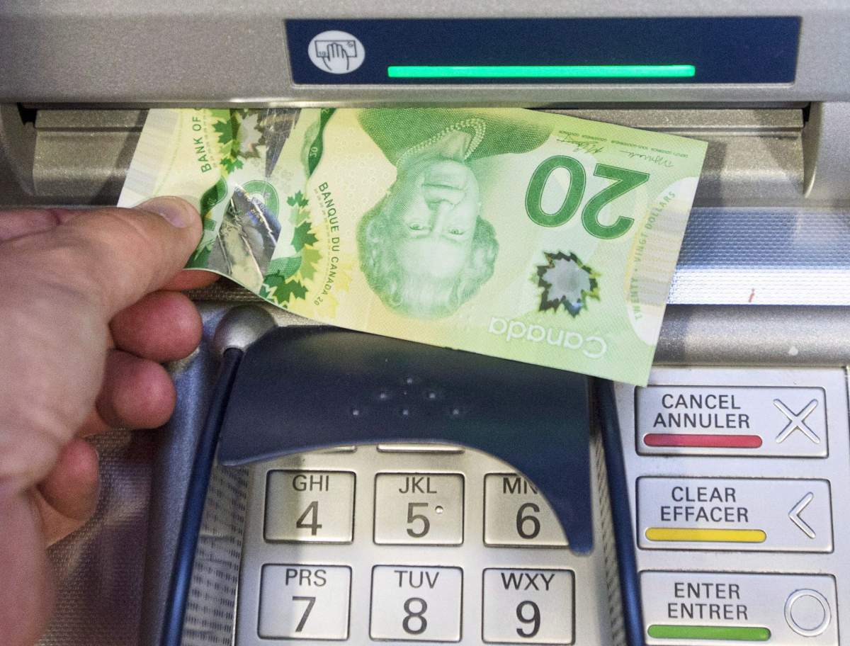 Money is removed from a bank machine on Monday, May 30, 2016 in Montreal.