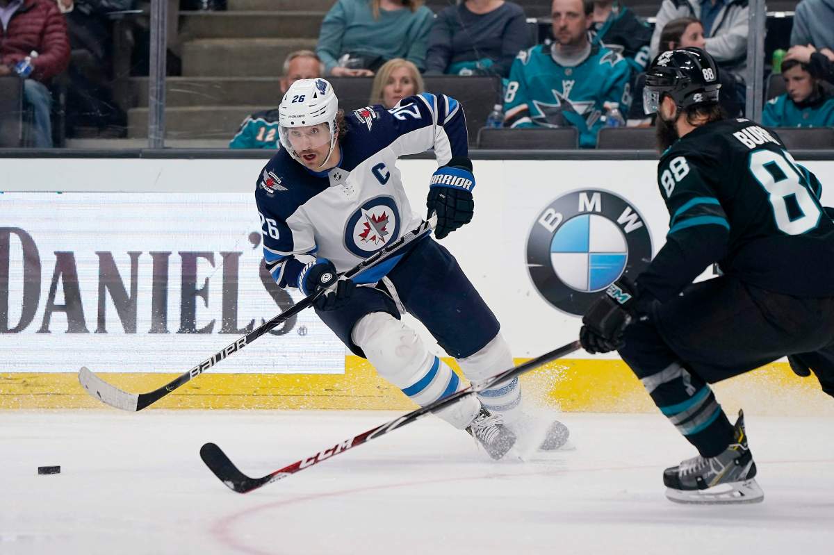 Winnipeg Jets right wing Blake Wheeler (26) moves the puck next to San Jose Sharks defenceman Brent Burns (88) during the second period of an NHL hockey game in San Jose, Calif., Friday, Nov. 1, 2019.