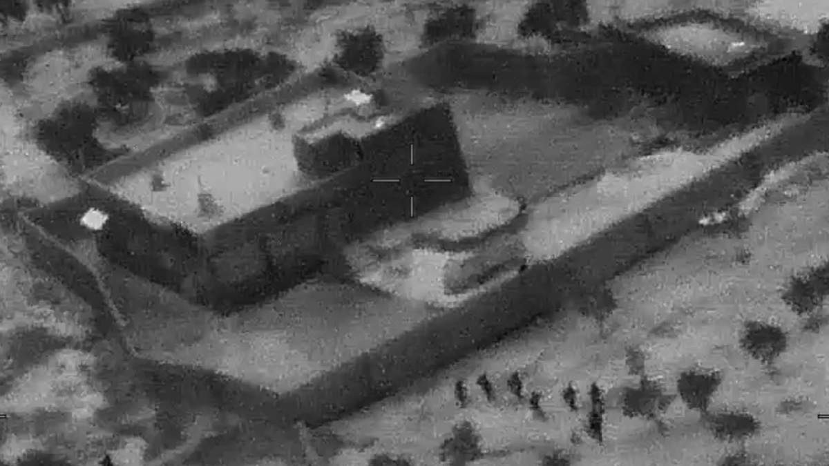 This Oct. 26, 2019, file image from video released by the Department of Defense, and displayed at a Pentagon briefing, shows U.S. Special Forces, figures at lower right, moving toward compound of Islamic State leader Abu Bakr al-Baghdadi.