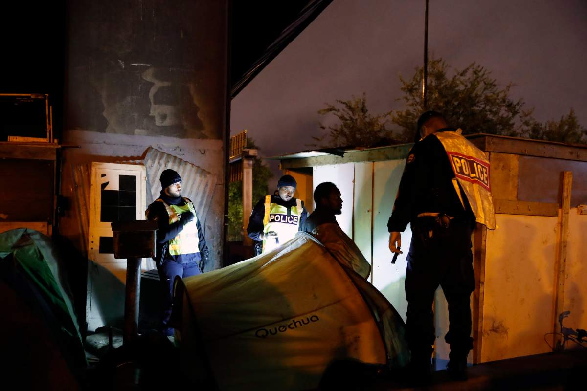 French Police officers evacuate a migrant during a large operation to dismantle makeshift migrant camps in the north of Paris, Thursday, Nov. 7, 2019. (AP Photo/Francois Mori)