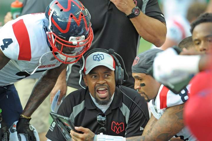 In this file photo, Montreal Alouettes head coach Khari Jones, centre, goes over a play with quarterback Vernon Adams Jr., right, during first half CFL football action against the Saskatchewan Roughriders in Regina on September 14, 2019. 