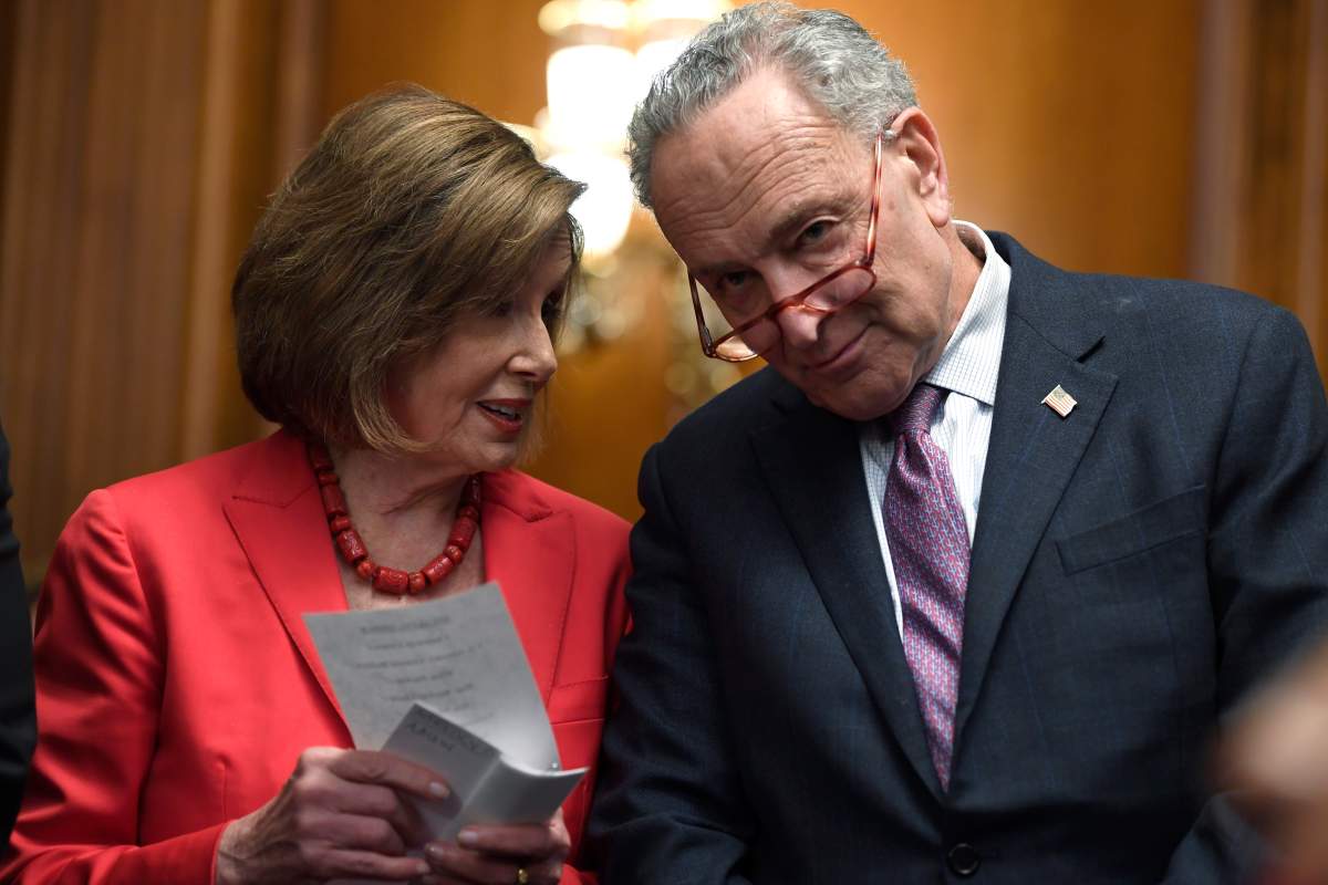 House Speaker Nancy Pelosi of Calif., left, and Senate Minority Leader Sen. Chuck Schumer of N.Y., right, talk as they wait to speak at an event on Capitol Hill in Washington, Nov. 12, 2019.