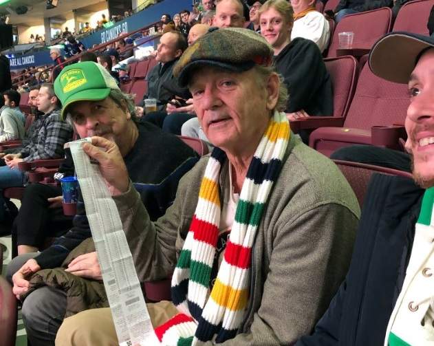Actor Bill Murray holds up 50-50 tickets with filmmaker Peter Farrelly, left, at a Vancouver Canucks game on Tuesday, Nov. 12, 2019.