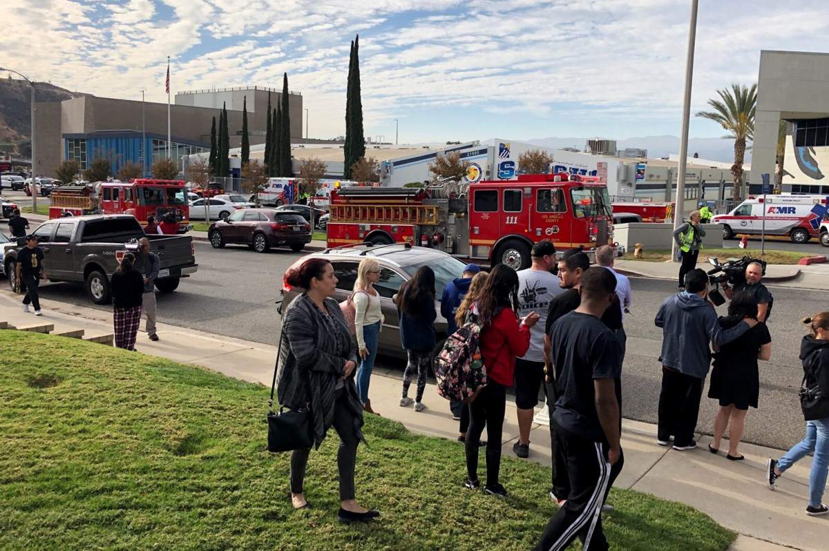 People wait for students and updates outside of Saugus High School after reports of a shooting on Thursday, Nov. 14, 2019, in Santa Clarita, Calif. (AP Photo/Marcio Jose Sanchez)