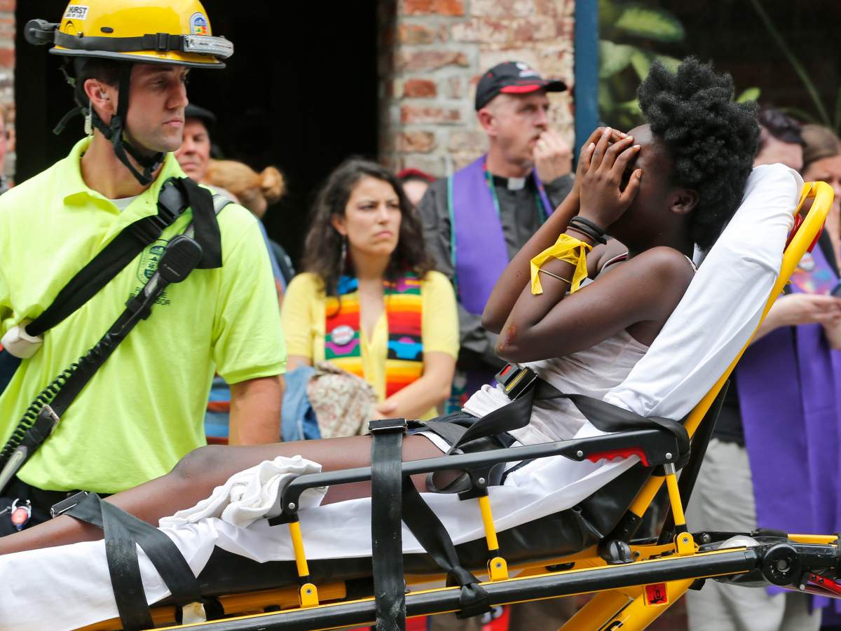 FILE - In this Aug. 12, 2017, file photo, an emergency employee helps an injured person after a neo-Nazi drove his car into a group of counter-protesters at a white nationalist rally in Charlottesville, Va.