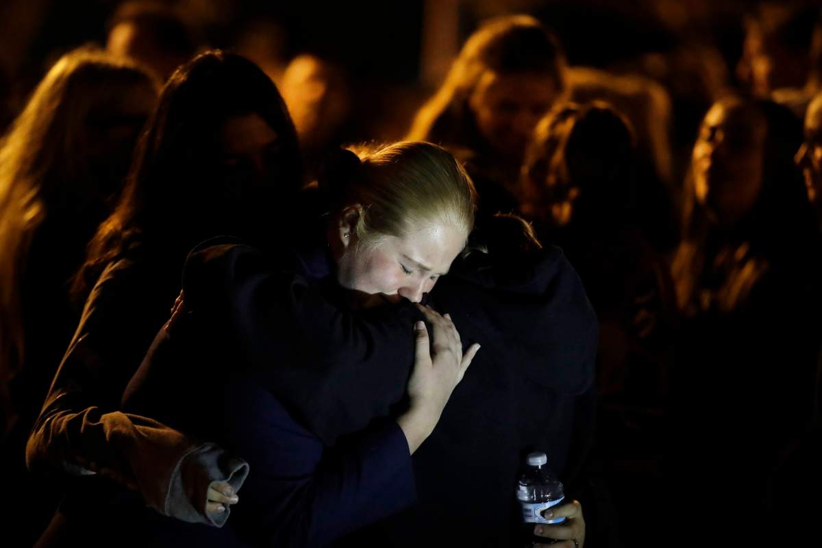 Students embrace during a vigil at Central Park in the aftermath of a shooting at Saugus High School Thursday, Nov. 14, 2019, in Santa Clarita, Calif. (AP Photo/Marcio Jose Sanchez)