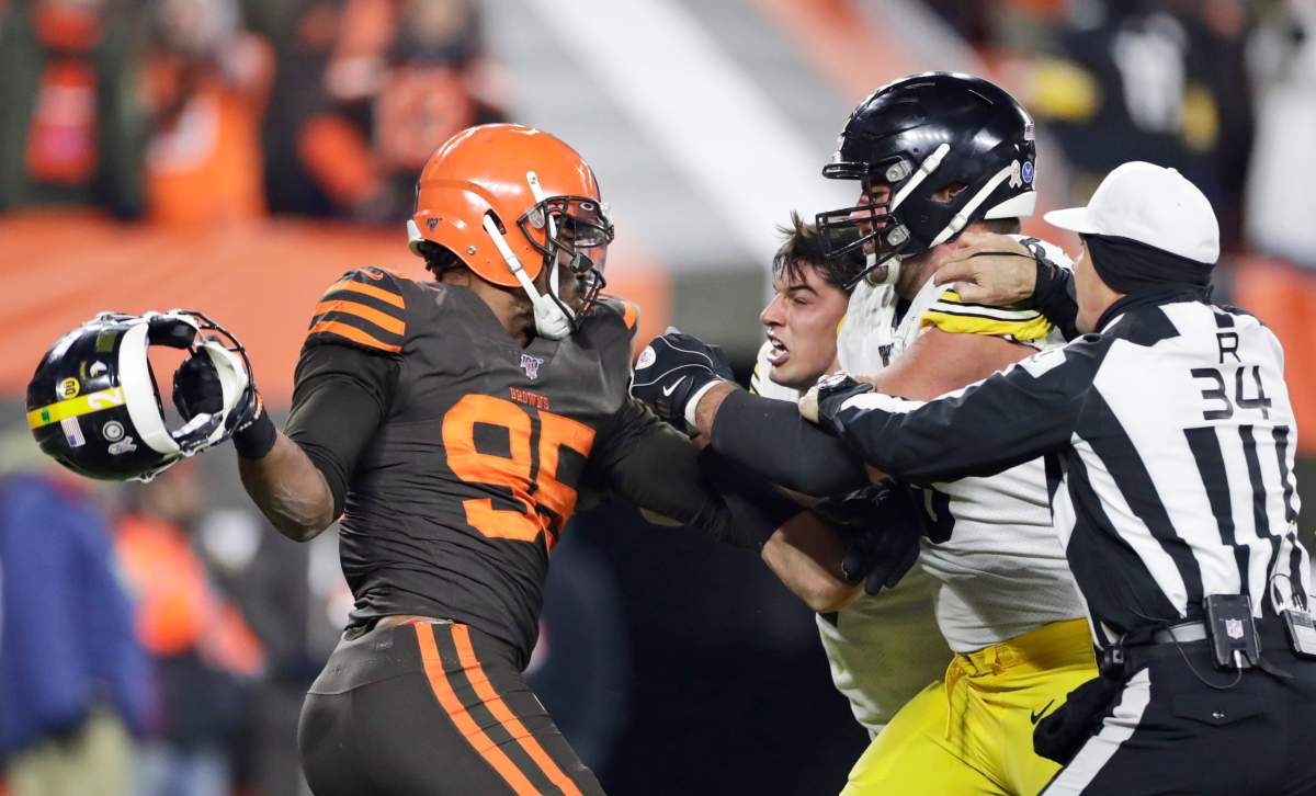 Cleveland Browns defensive end Myles Garrett, left, gets ready to hit Pittsburgh Steelers quarterback Mason Rudolph, second from left, with a helmet during the second half of an NFL football game Thursday, Nov. 14, 2019, in Cleveland. The Browns won 21-7.