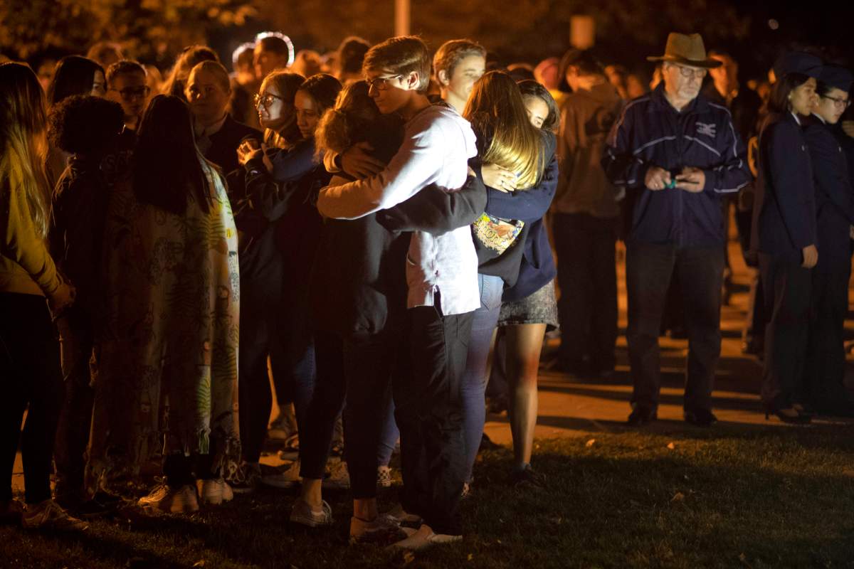 People affected by the Saugus High School shooting comfort each other during a vigil at Central Park in Santa Clarita, Calif., Thursday, Nov. 14, 2019. (Hans Gutknecht/The Orange County Register via AP)