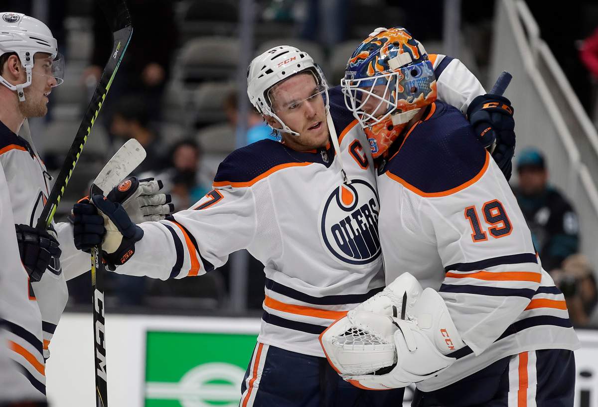 Edmonton Oilers goalie Mikko Koskinen (19) celebrates with Connor McDavid at the end of an NHL hockey game against the San Jose Sharks on Tuesday, Nov. 19, 2019, in San Jose, Calif. (AP Photo/Ben Margot).