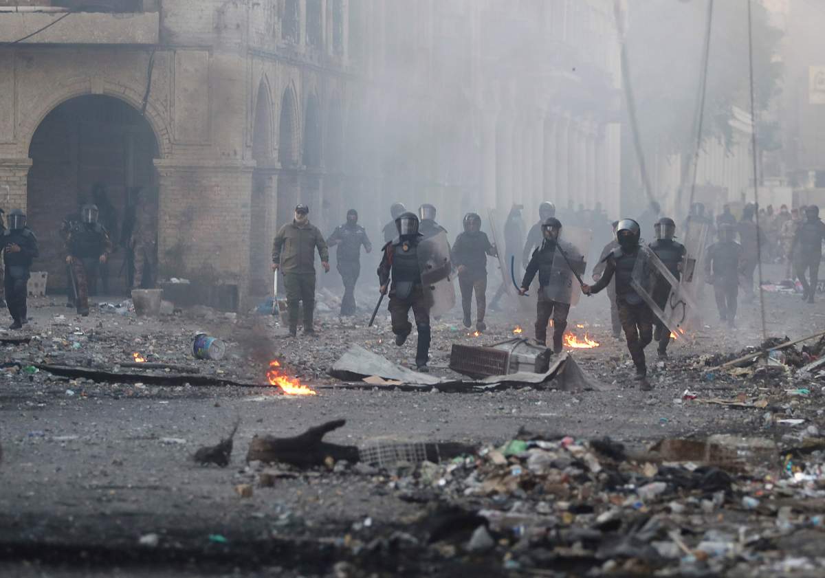 Riot police try to disperse anti-government protesters during clashes in Baghdad, Iraq, Nov. 23, 2019.