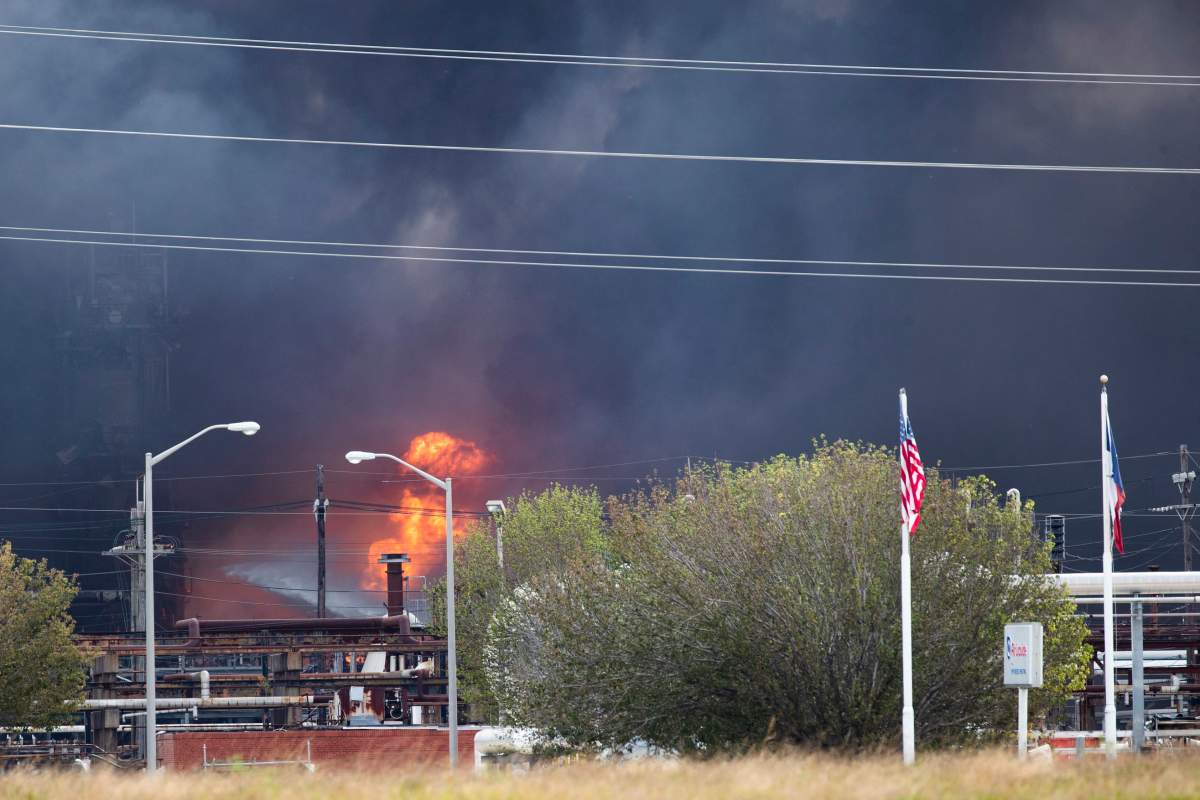 Smoke and fire are visible from the TPC Group Port Neches Operations explosion on Wednesday, Nov. 27, 2019, in Port Neches, Texas.  (Marie D. De Jesus /Houston Chronicle via AP)