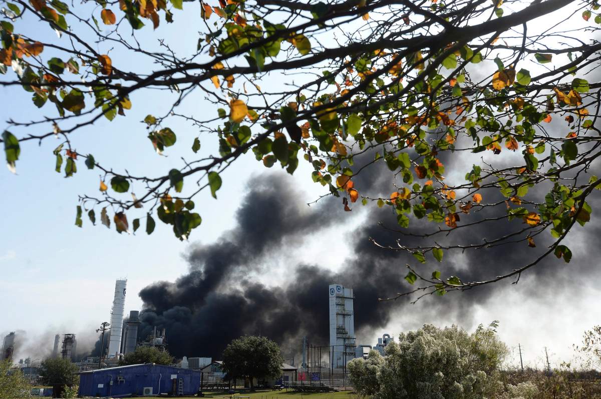 Thick smoke fills the sky above the TPC plant as emergency response crews try to contain the fire that continued to burn throughout the morning following an overnight explosion in Port Neches, Texas. (Kim Brent/The Beaumont Enterprise via AP)