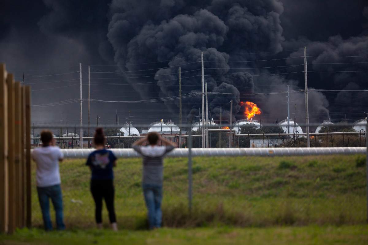 Residents observe the fire consuming the TPC Group plant. (Marie D. De Jesús/Houston Chronicle via AP)