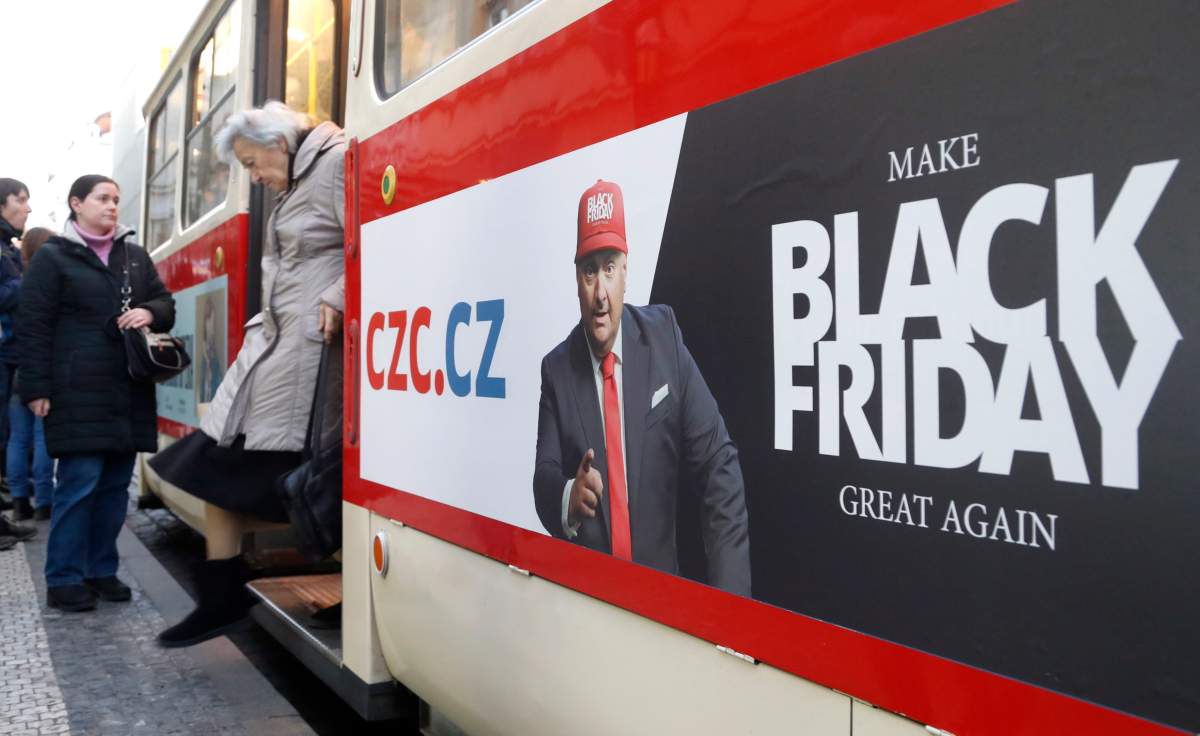 A woman gets off a tram advertising the Black Friday in Prague, Czech Republic, Nov. 28, 2019.