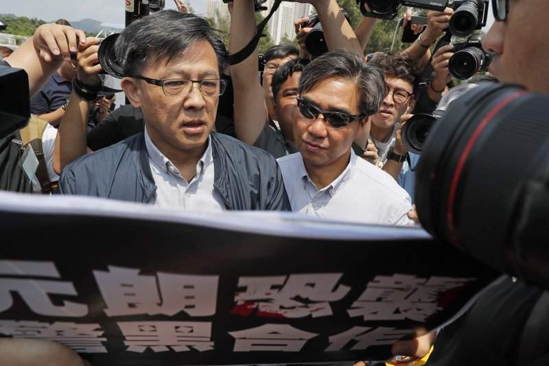 In this Aug. 12, 2019, photo, pro-Beijing lawmaker Junius Ho, left, attends a demonstration of an anti-riot vehicle equipped with water cannon at the Police Tactical Unit Headquarters in Hong Kong. Hong Kong police say an anti-government supporter stabbed and wounded the pro-Beijing lawmaker who was campaigning for local elections. The government condemned the attack on Wednesday, Nov. 6, 2019 against Ho, a hate figure for protesters, and said police arrested the assailant. 