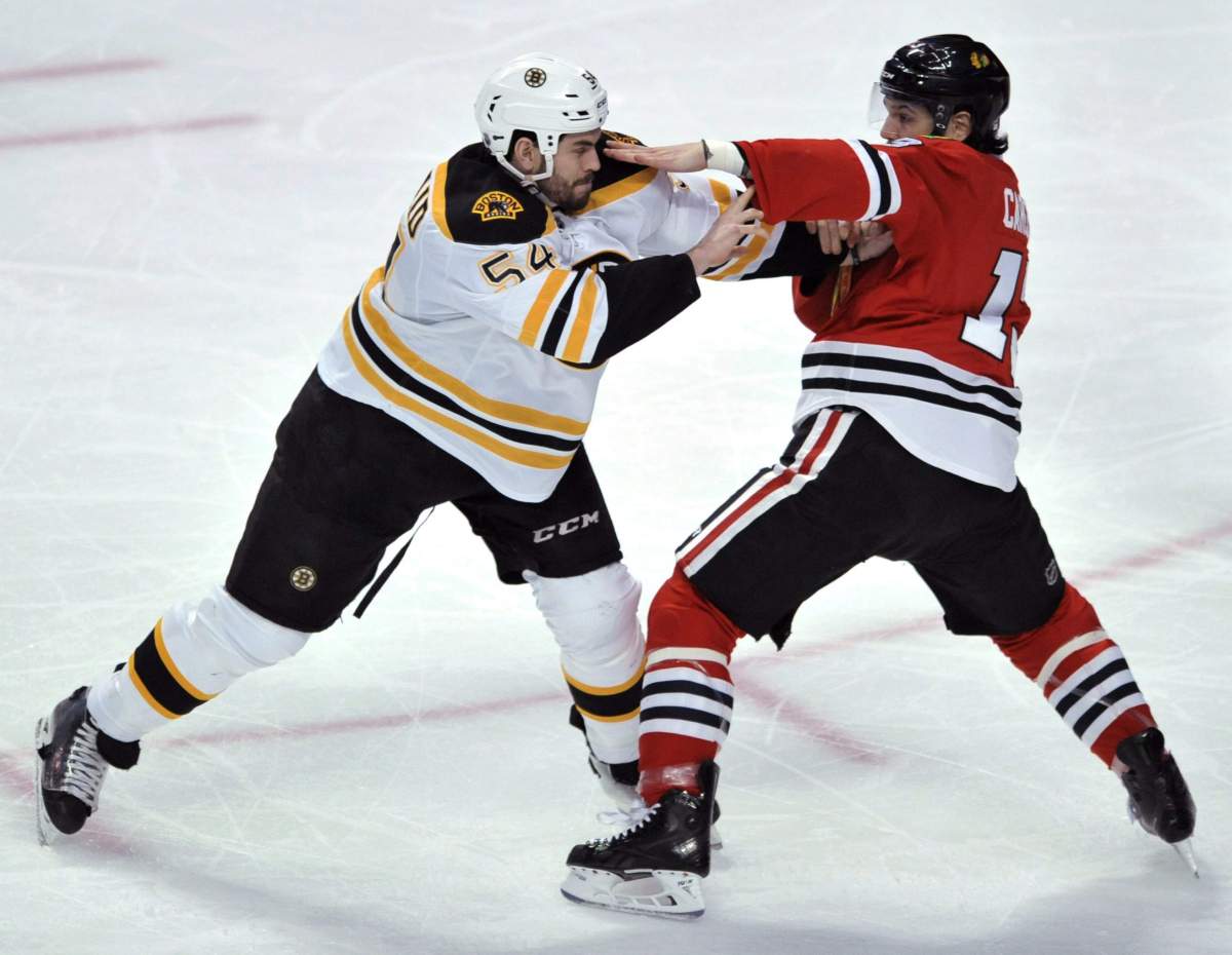 Boston Bruins’ Adam McQuaid (54), fights with Chicago Blackhawks’ Daniel Carcillo (13), during the second period of an NHL hockey game Sunday, Feb. 22, 2015 in Chicago.