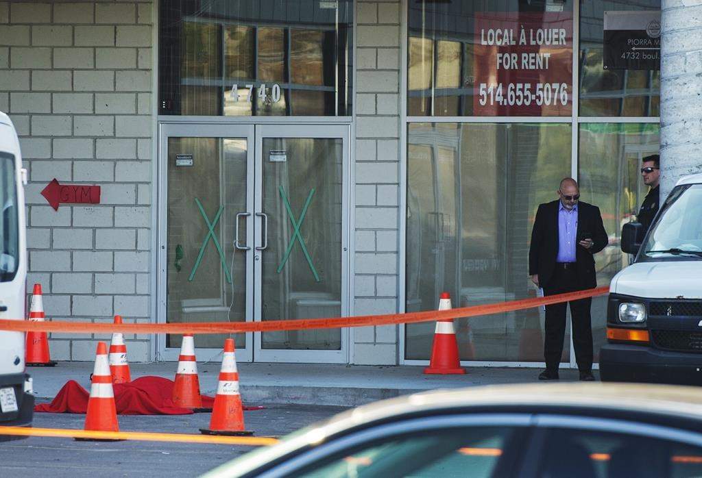 Investigators stand near the body of alleged mob boss Andrew Scoppa, who was shot to death, in Montreal, Monday, Oct. 21, 2019. After recording 17 organized crime-related killings in the greater Montreal area since Jan 1., Quebec and Montreal police announced Wednesday the creation of a permanent mixed squad dedicated to investigating groups such as the Mafia and the Hells Angels.