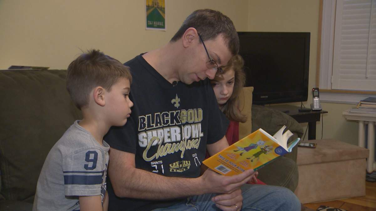 Halifax homeowner Darren Jordan reads with his two young children on Nov. 28, 2019.