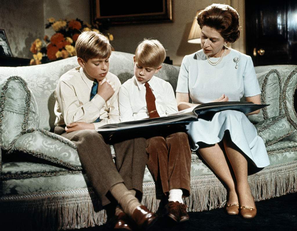 Queen Elizabeth II reads a book with Prince Andrew (L) and Prince Edward at Buckingham Palace during the recording of Queen’s Christmas message to the Commonwealth in December 1971.