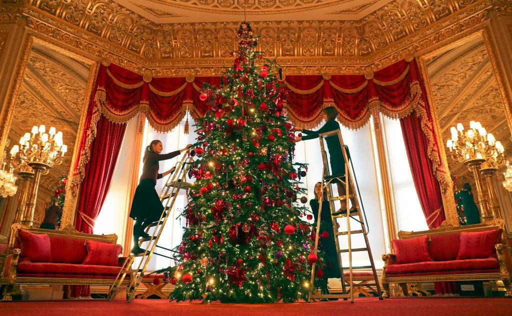 Royal Collection Trust members of staff put the finishing touches to a 15ft Christmas tree in the Crimson Drawing Room at Windsor Castle, Berkshire.