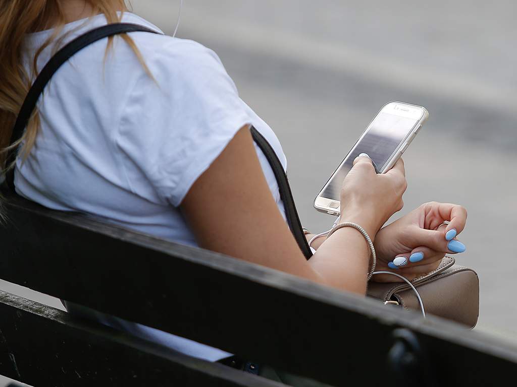 A young woman is seen using her smartphone by a tram stop on 19 August, 2017, in Bydgoszcz, Poland.