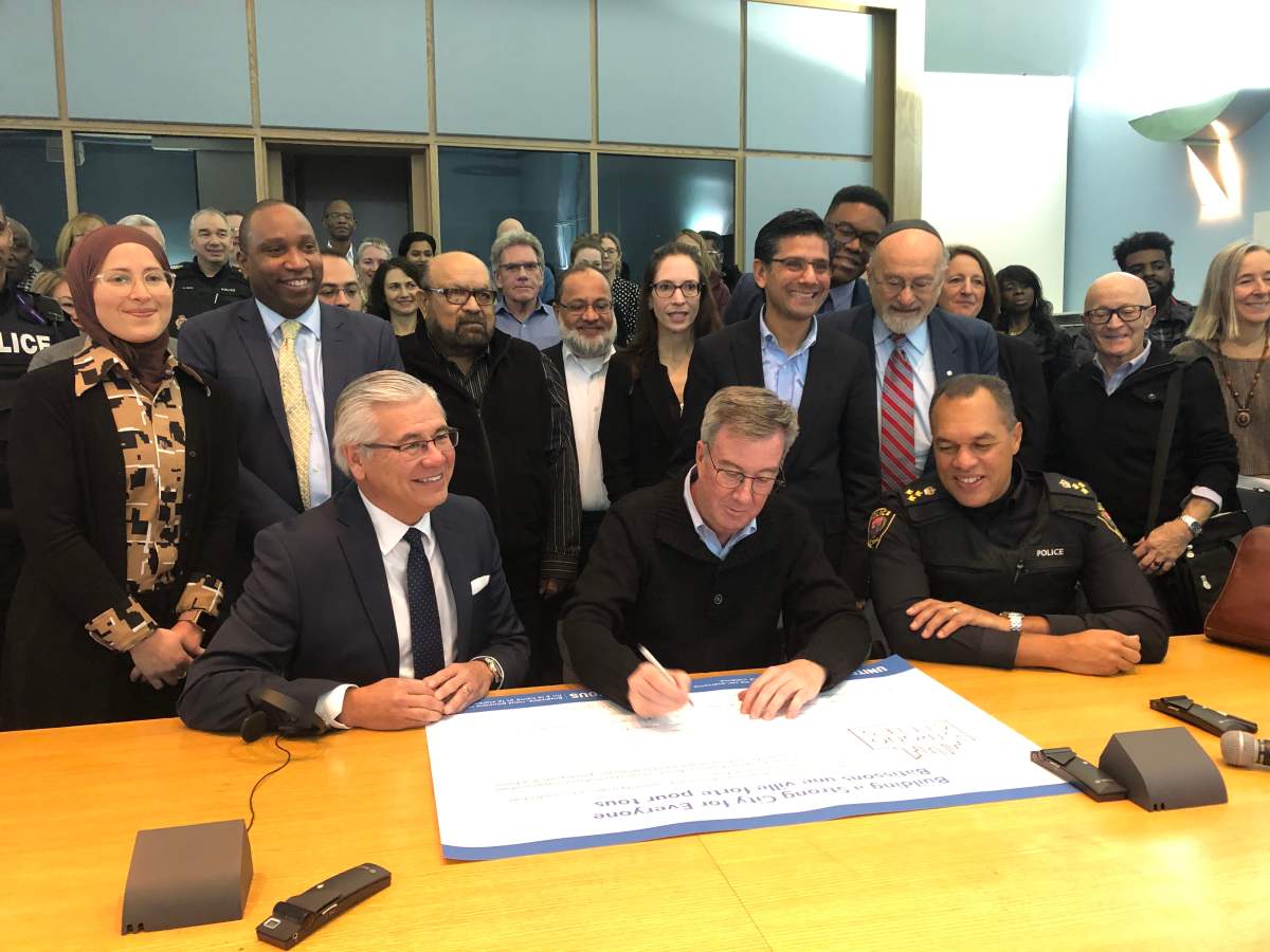 United Way East Ontario CEO Michael Allen, Mayor Jim Watson, police Chief Peter Sloly along with partner members of the newly founded United for All coalition sign the UN Strong Cities Network pledge at city hall on Friday.