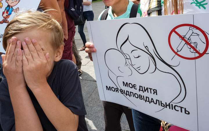 A boy attends a protest by anti-vaccination activists in Kiev. The banner reads: "My baby is my responsibility.".