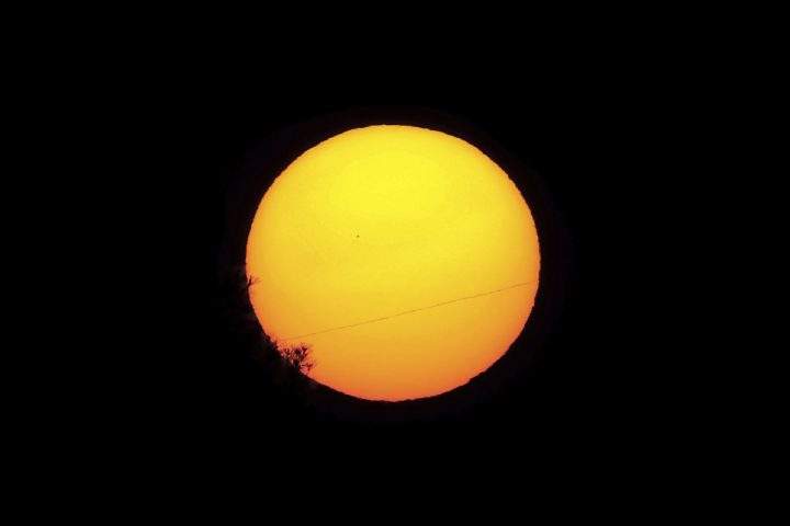 Planet Mercury is seen as a small silhouette, center left, as it travels across the face of the sun, near capital Nicosia, Cyprus, Monday, Nov. 11, 2019.