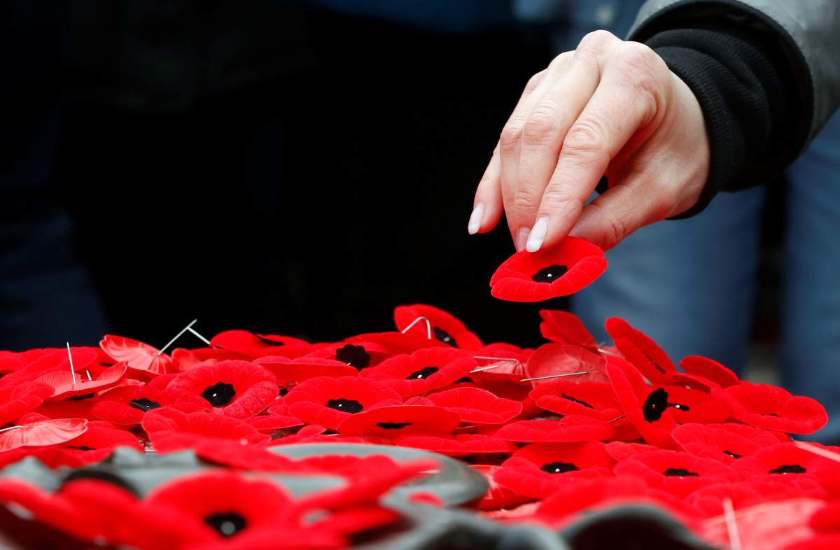 A woman places a poppy on the Tomb of the Unknown Soldier at the National War Memorial on Remembrance Day in Ottawa, Nov. 11, 2019.