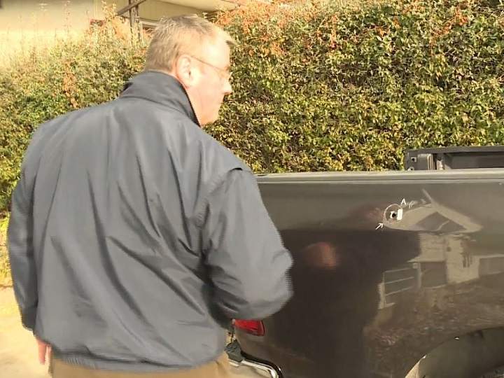 Brad Albrecht looks at his truck, and the bullet hole in the box, following an unconfirmed drive-by shooting in Vernon on Friday afternoon.