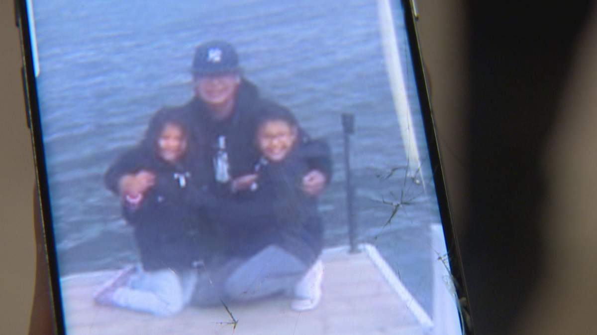 Skyrah and one of her older sisters pose with their grandfather.