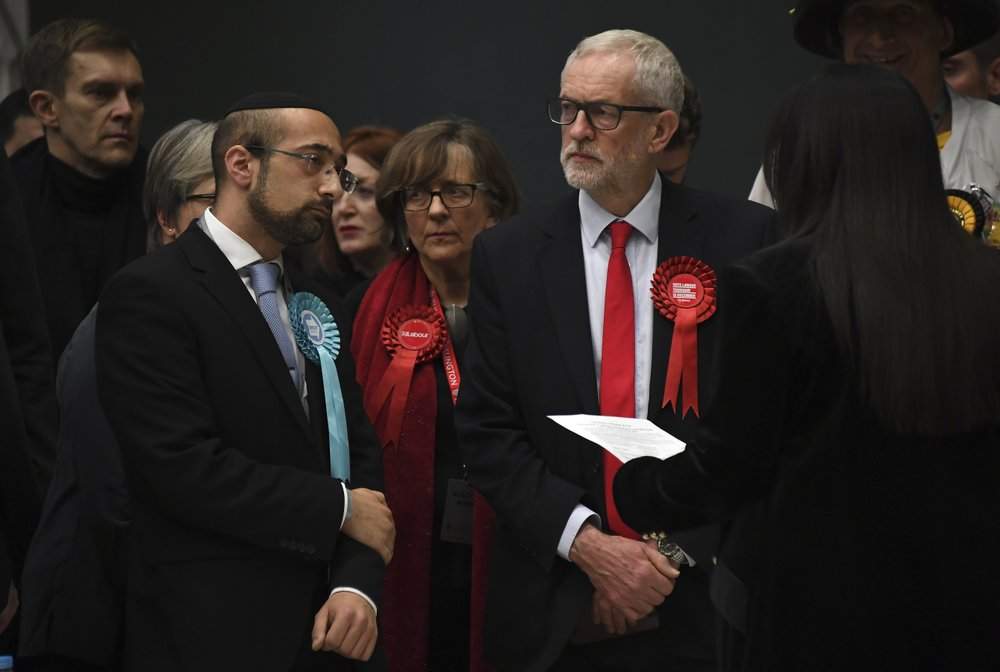 British opposition Labour Party leader Jeremy Corbyn, right, waits for the declaration of his seat in the 2019 general election in Islington, London, Friday, Dec. 13, 2019. The first handful of results to be declared in Britain's election are showing a surge in support for to the Conservatives in northern England seats where Labour has long been dominant. 