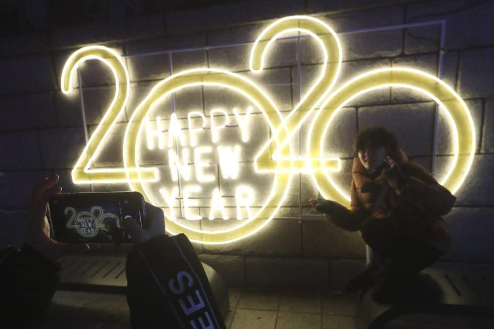 A woman poses for photos to celebrate the upcoming New Year in Seoul, South Korea, Tuesday, Dec. 31, 2019.