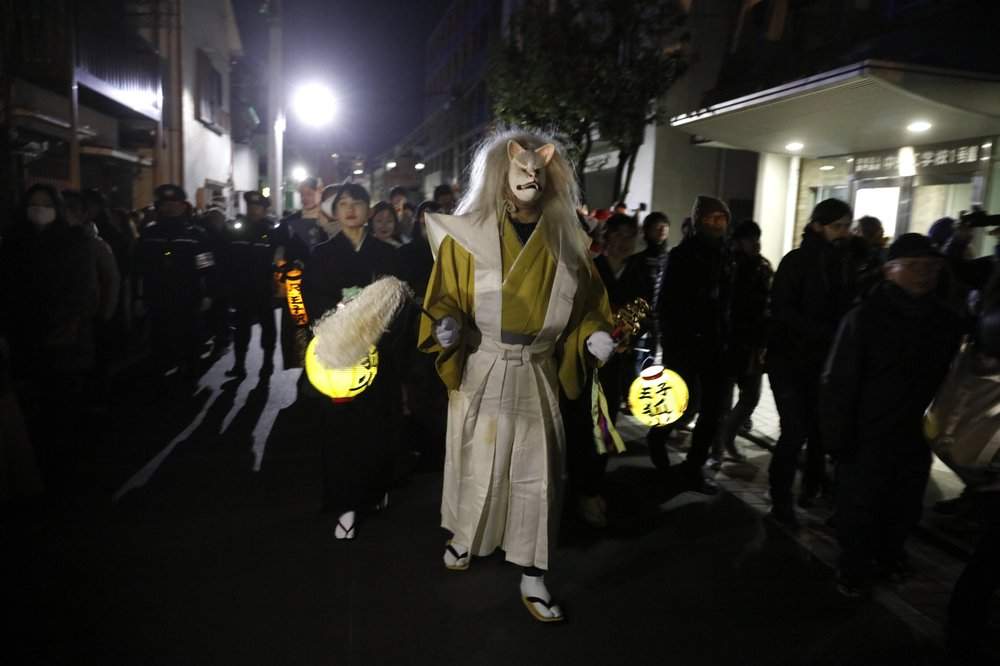 A man wearing a fox mask participates in a parade held to celebrate the New Year Wednesday, Jan. 1, 2020, in Tokyo.