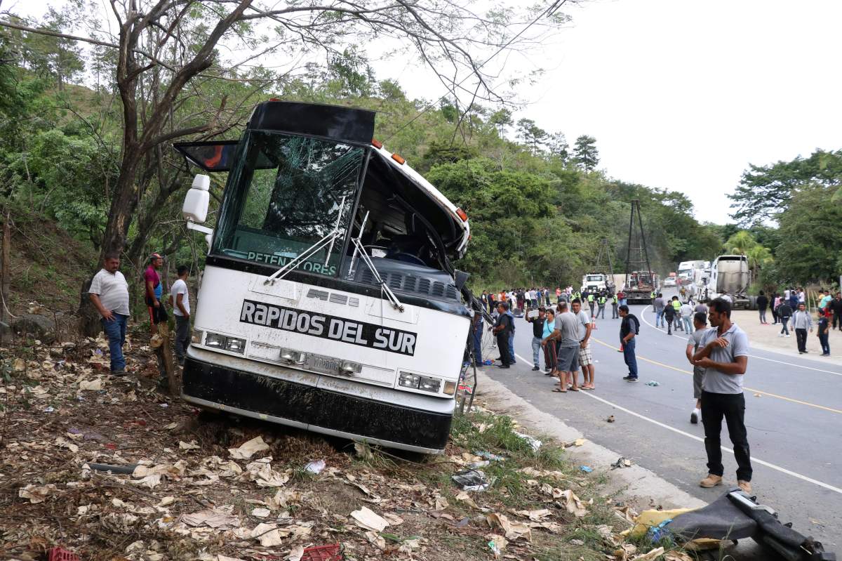 People are pictured on the scene of a collision between a passenger bus and a trailer truck early on Saturday in Gualan, near Guatemala’s Atlantic coast, Guatemala, on Dec. 21, 2019.