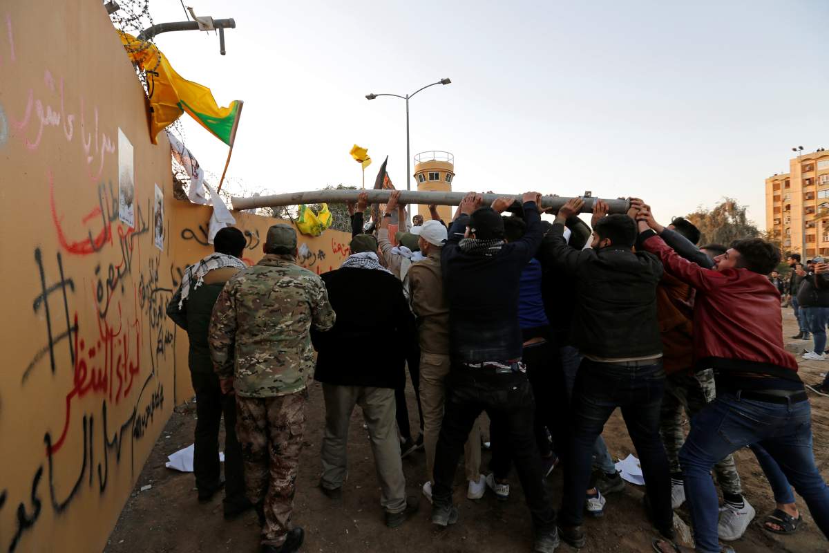 Protesters and militia fighters attack the U.S. Embassy during a protest to condemn air strikes on bases belonging to Hashd al-Shaabi (paramilitary forces), in Baghdad, Iraq December 31, 2019.