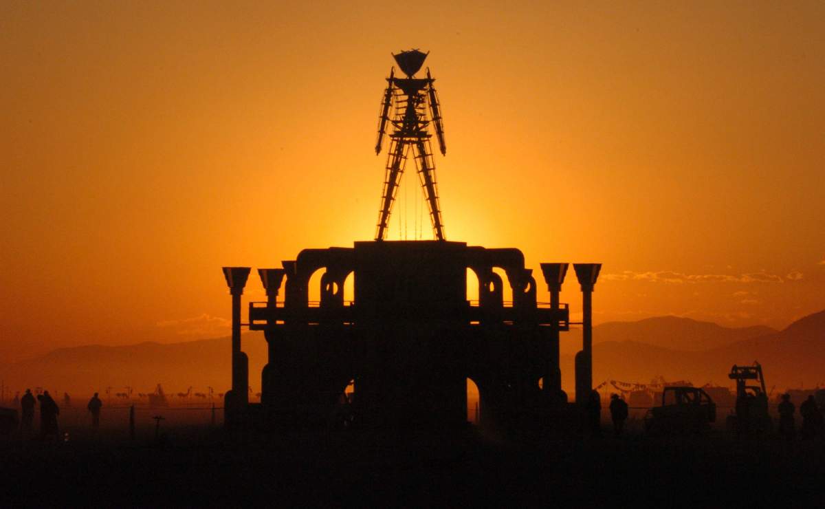 In this Sept. 2, 2006 file photo, ‘The Man,’ a stick figured symbol of the Burning Man art festival, is silhouetted against a morning sunrise in Nevada’s Black Rock Desert.