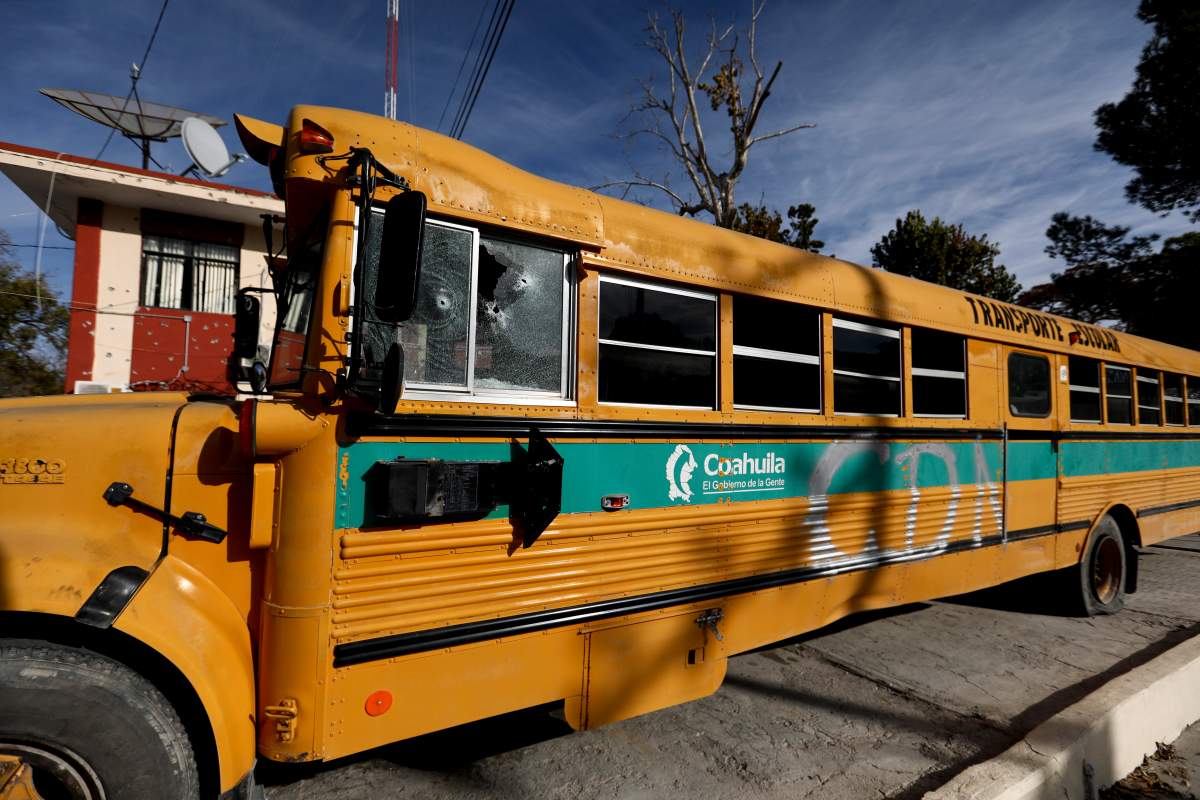 A school bus is sprayed with the initials C.D.N., which stands for the “Cartel del Noreste” cartel, outside City Hall in Villa Union, Mexico, Dec. 2, 2019.