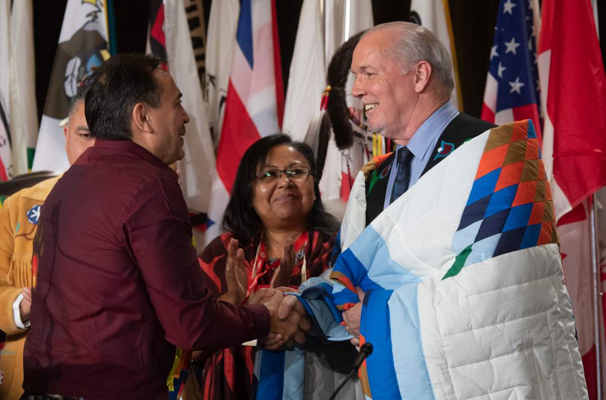 Assembly of First Nations Chief Perry Bellegarde speaks with B.C. Premier John Horgan after he was presented with a blanket during a ceremony at the Assembly of First Nations Special Chiefs Assembly in Ottawa, Tuesday, Dec. 3, 2019. 