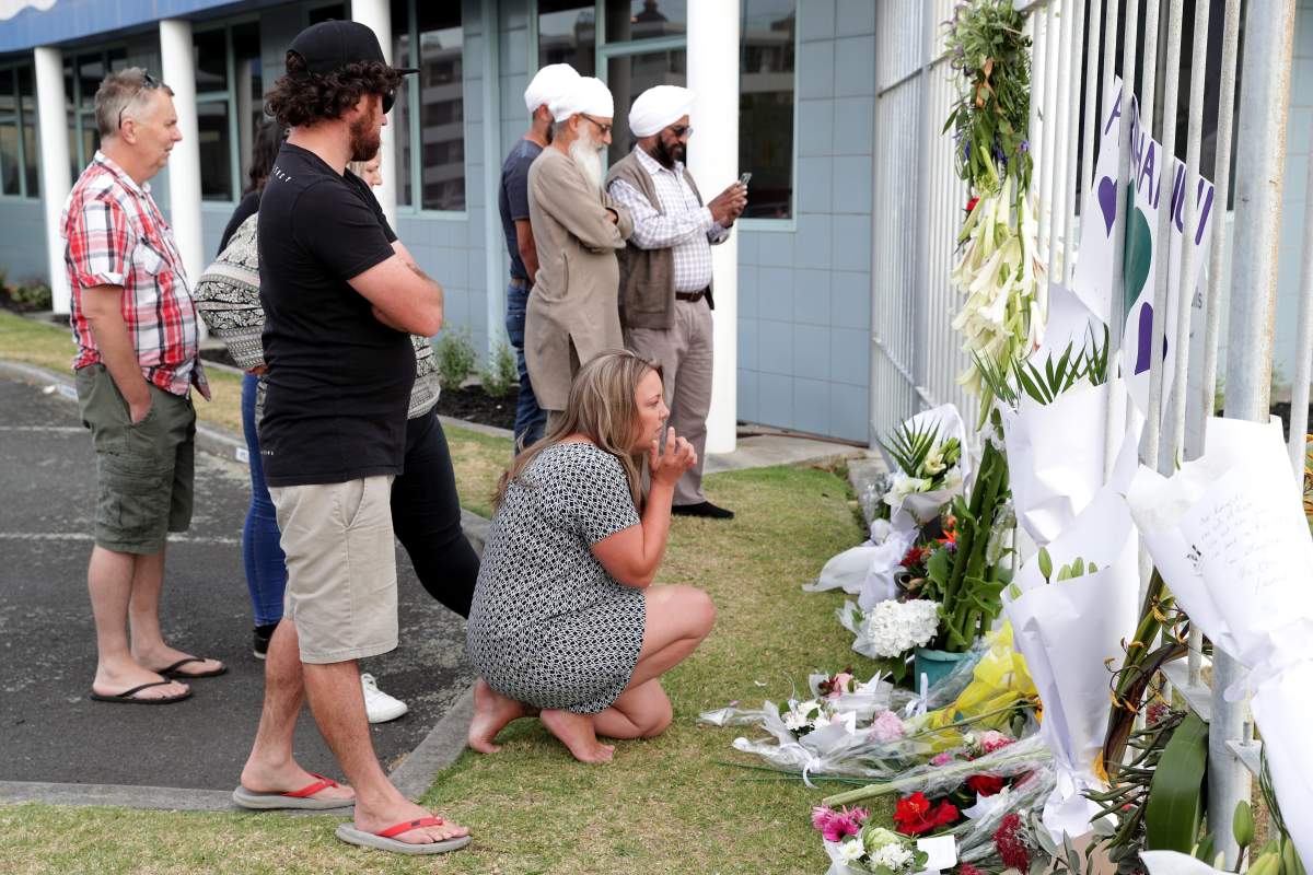 People lay flowers at the entrance to the Port of Tauranga where the Ovation of the Seas cruise ship is berthed, in Tauranga, New Zealand, December 10, 2019.