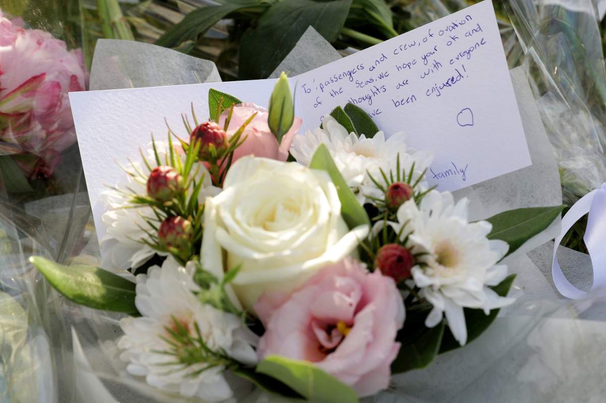 Floral tributes lie at the gates of the port where the cruise ship Ovation of the Seas is berthed, in Tauranga, New Zealand, December 10, 2019.