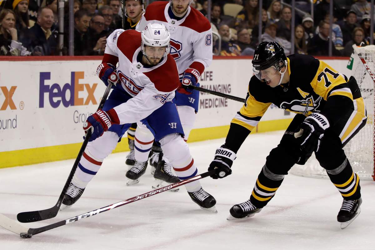 Pittsburgh Penguins' Evgeni Malkin pokes the puck off the stick of Montreal Canadiens' Phillip Danault (24) during the second period of an NHL hockey game in Pittsburgh, Tuesday, Dec. 10, 2019. 