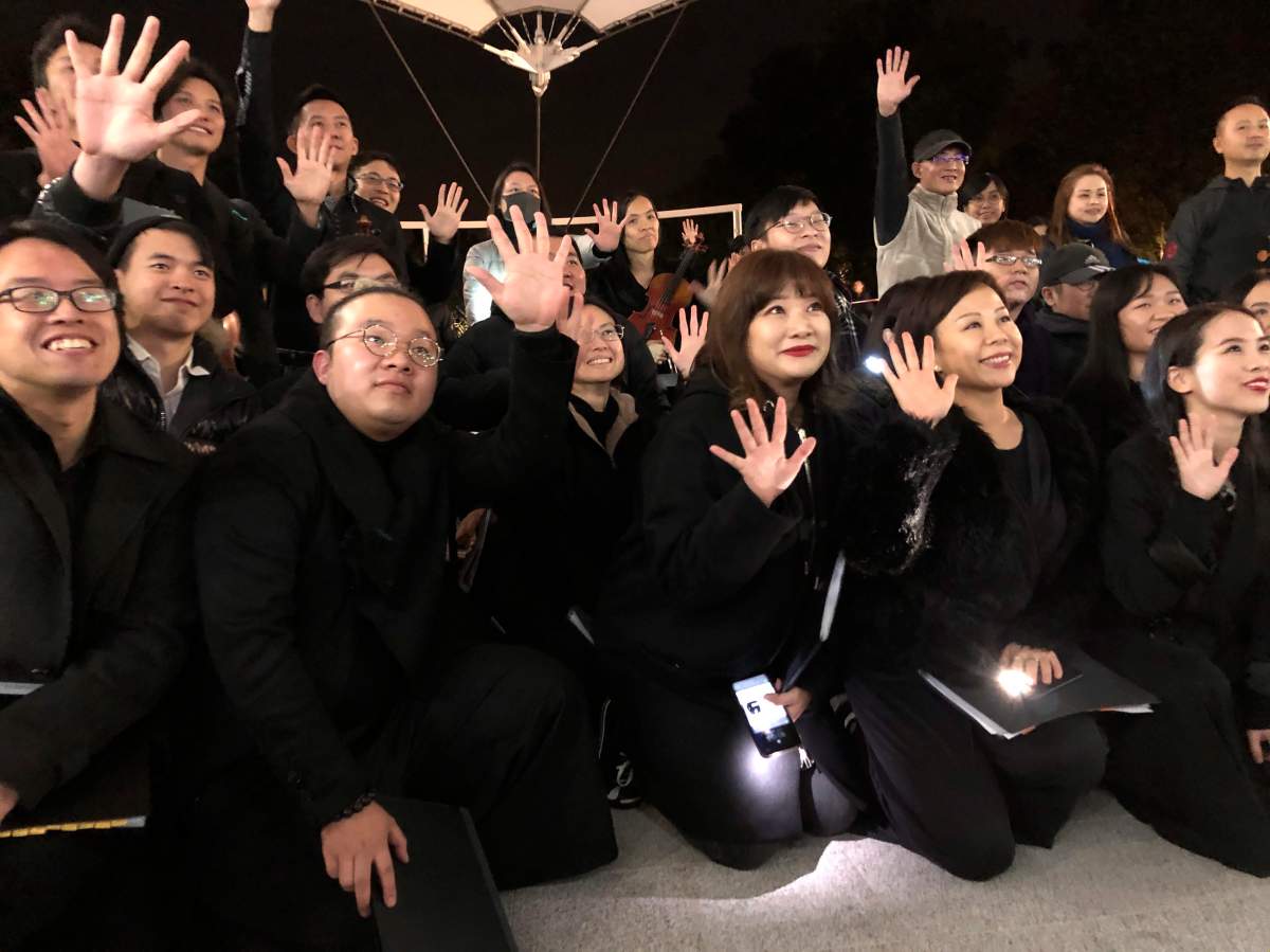In this Dec. 10, 2019 photo, members of a theatre troupe raise their hands to symbolize the five demands of pro-democracy protesters after a performance of Les Miserables in at an outdoor event space in Hong Kong.