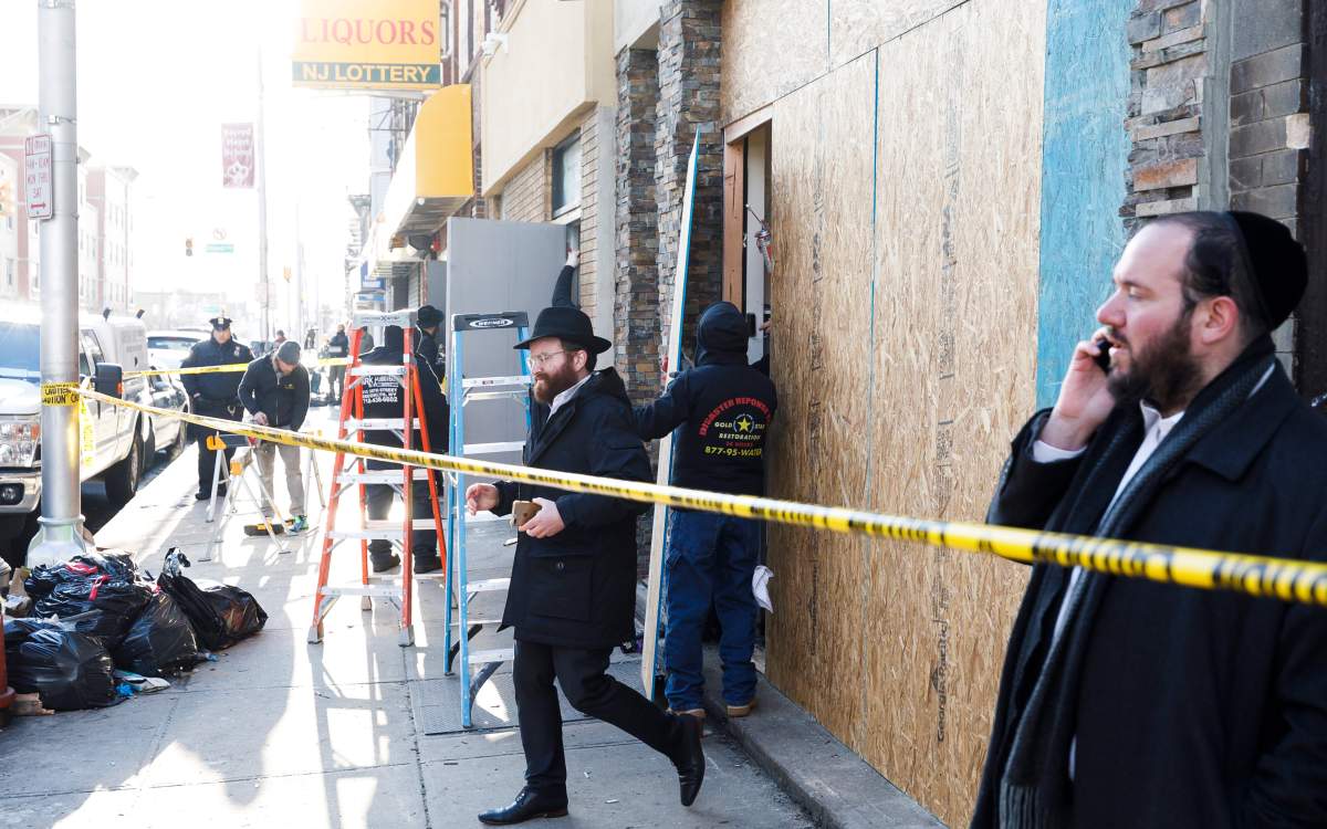 Workers board up the front of the kosher market which was the scene of multiple shooting in Jersey City, New Jersey, USA, Dec. 11, 2019.