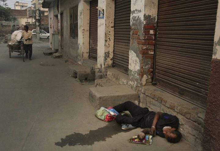 In this Oct. 31, 2019, photo, an Indian drug addict lies unconscious by the side of a road in Kapurthala, in the northern Indian state of Punjab.
